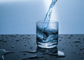 Glas mit Wasser Wasser fließt in ein Glas