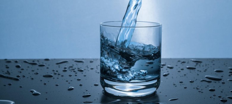 Wasser fließt in ein Glas